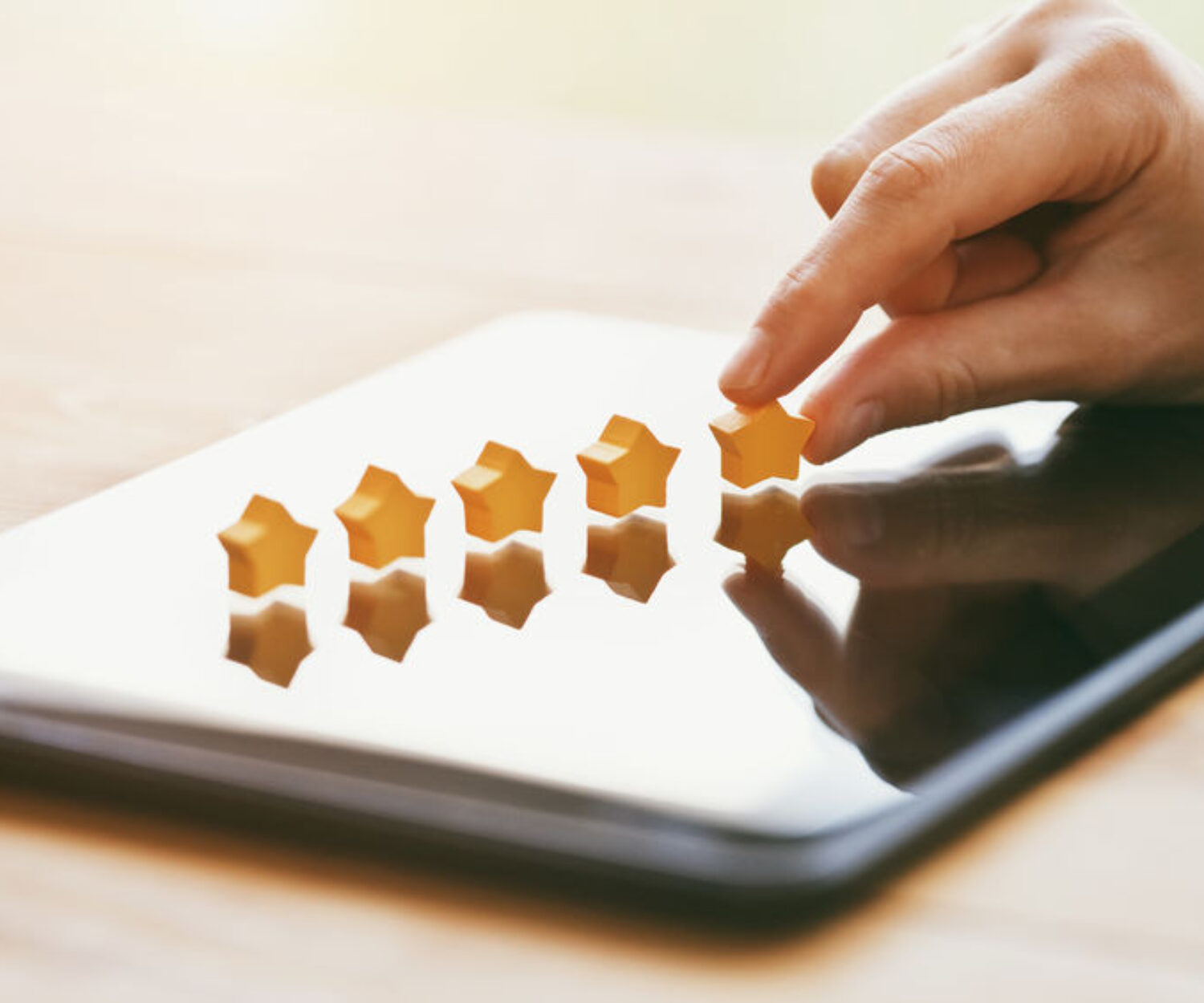 hand gives five stars rating as product feedback with tablet computer